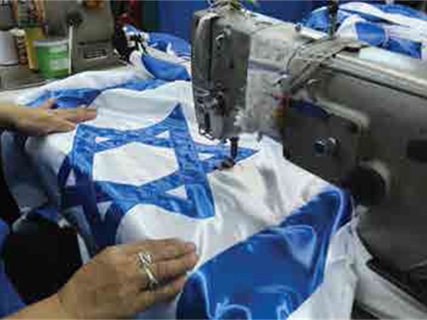 Sewing an Israeli flag at a workshop in