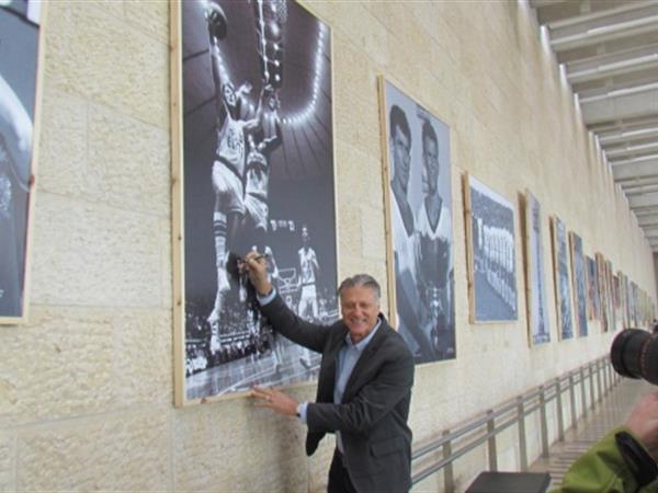 כדורסלן העבר מיקי ברקוביץ חותם על הכרזה המוצגת בתערוכה